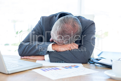Tired businessman resting on desk