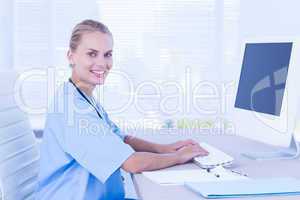 Happy doctor using computer