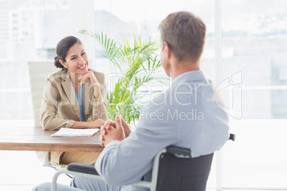 Smiling businesswoman interviewing disabled candidate