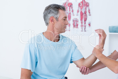 Doctor examining her patient arm