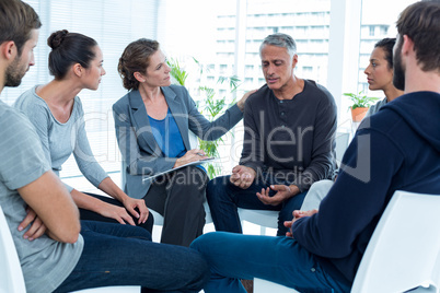 Concerned woman comforting another in rehab group