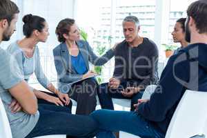 Concerned woman comforting another in rehab group