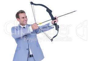 Happy businessman shooting with bow and arrow