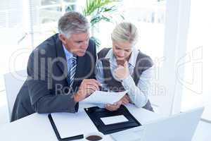 Businessman with secretary checking file