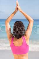 Beautiful fit woman doing yoga beside the sea