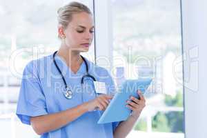 Serious doctor looking at clipboard