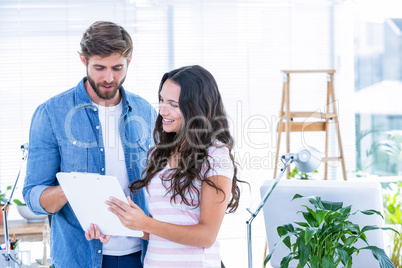 Creative business people looking at clipboard