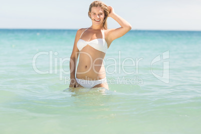 Happy pretty blonde looking at camera into the sea