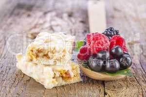 muesli bars with fresh berries in spoon on wooden