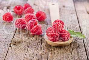 fresh raspberry in wooden spoon on wooden table