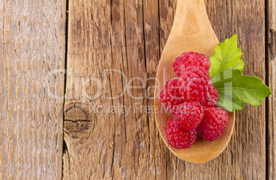 fresh raspberry in wooden spoon on wood