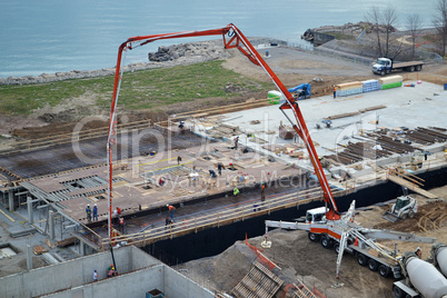 Pouring concrete on construction side.