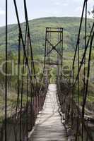 hinged bridge over mountain river