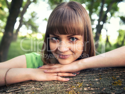 Young sensual girl leaning against a tree