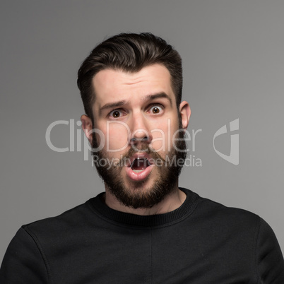 Portrait of a young puzzled businessman with opened mouth