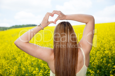 Women formed with long brown hair and hands to the heart