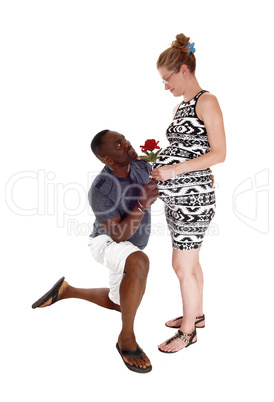 Black man kneeling for white pregnant woman.