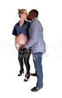 Black man kissing his pregnant white woman.