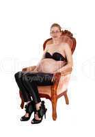 Pregnant white woman in armchair.