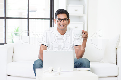 Indian male using computer at home.