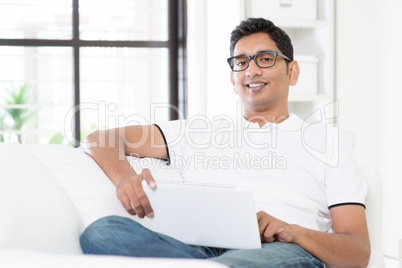 Indian man using digital computer tablet