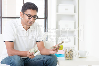 Sad Indian guy counting money