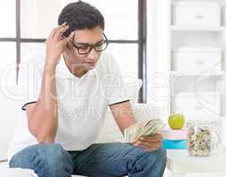 Stressed Indian guy counting money