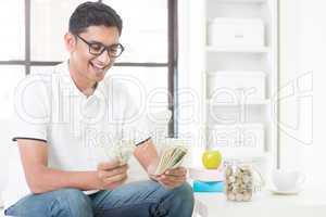 Happy Indian guy counting money