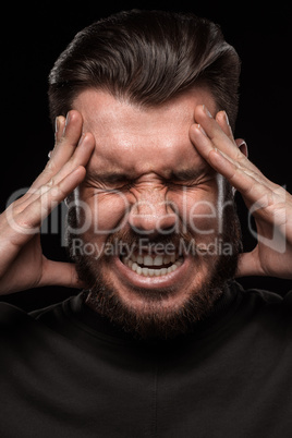 Stressed businessman with a headache over black