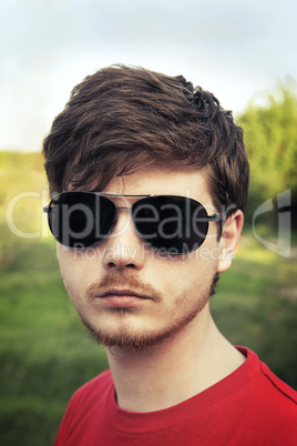 young guy in sunglasses close-up outdoors