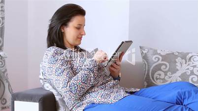 Beautiful young woman relaxing with a digital tablet computer