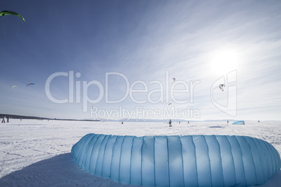 Kiteboarder with blue kite on the snow