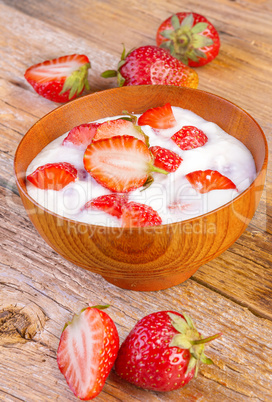 fresh organic greek yogurt with strawberries on wooden