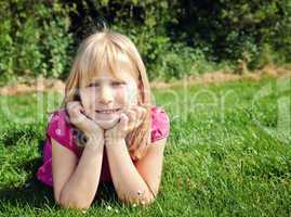 young girl lying on grass