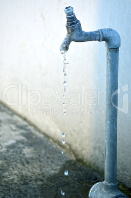 Tap of running water isolated on grey background