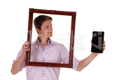 Man looking trough picture frame.
