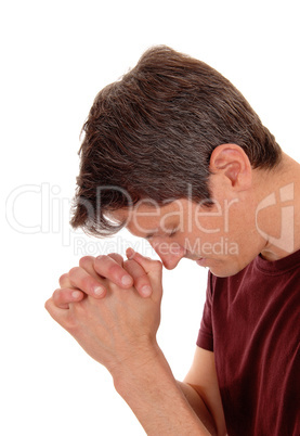 Praying young man in profile.