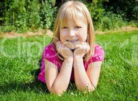 young girl lying on grass