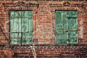 Old window with closed shutters on a brick wall
