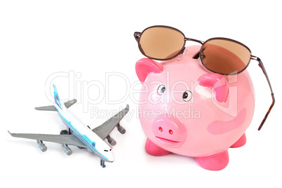 Sparschwein mit Sonnenbrille und Spielzeugflugzeug