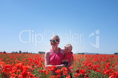 mom and little baby on the poppy fields