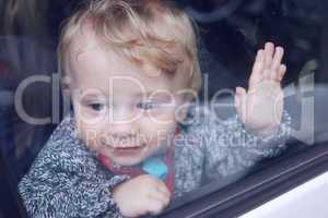 little boy looking from the car window