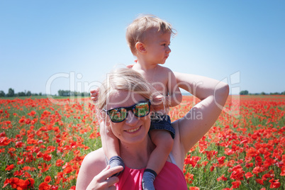 mom and little baby on the poppy fields