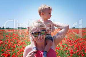 mom and little baby on the poppy fields