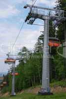 Empty chairlift with red passenger gondolas