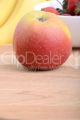 Fruits. Arrangement of various fresh ripe fruits: bananas, apple and strawberries closeup