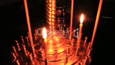 church candle burning in red candlestick