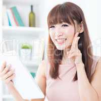 Asian girl using tablet showing peace hand sign