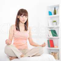 Asian girl meditating at home
