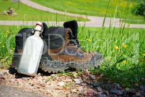 Wanderstiefel stehen am Rand eines Feldweges